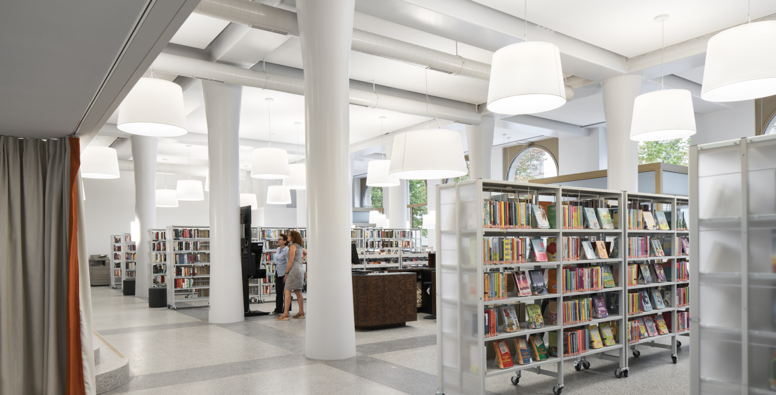 Heller Innenraum einer modernen Bibliothek mit Bücherregalen